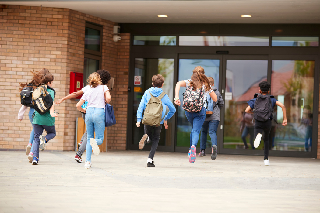 Group of High School Students Running into School Building at Be